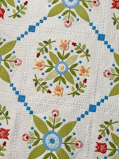 a close up of a quilt with flowers on it