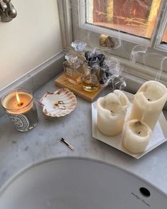 some candles are sitting on a counter next to a candle holder and an ashtray