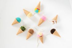 an assortment of ice cream cones with pom - poms on them are arranged in a circle