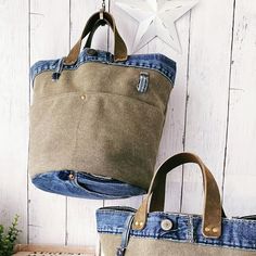 two bags hanging from hooks next to each other on a white wooden wall with a star in the background