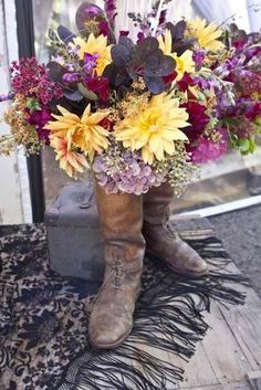 a boot with flowers in it sitting on a rug