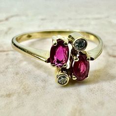 Fine vintage handcrafted 18 Karat yellow gold Toi-Et-Moi (bypass) ring set with 2 oval rubies weighing approximately 0.50 carat, and 2 round diamonds weighing approximately 0.05 carat, F-G VS. Stamped 750 with maker’s marks. This ring is a size 7.75 US / P 1/2 UK. > Resizing not included. This ring can be resized to fit most fingers. Please contact us for details. Resized rings are final sale. It weighs 2.3 grams. Birthstone: July/April. Condition: Very good. Minute scratches throughout metal. L Resize Ring, Bypass Ring, Maker’s Mark, Ruby Diamond, Buy Vintage, Yellow Gold Rings, Ring Set, Ring Sets, Round Diamonds