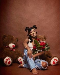 a woman sitting next to two teddy bears with flowers in her hair and holding roses