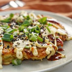 a white plate topped with food covered in sauce and toppings on top of it