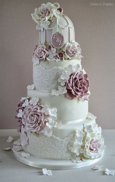 a three tiered wedding cake with flowers on the top and bottom layer is white