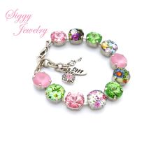 "Swarovski bracelet, Pink and Green Bracelet, Flower bracelet, Pastel bracelet Give your special someone a bouquet of flowers that will always bloom. The Everlasting Blooms bracelet features genuine 12mm Swarovski crystals, rose water opal rivolis and blooming flower cabochons in a soft feminine combination of light pinks and greens. The crystals are set in a high quality rhodium plated chain. The bracelet has an an adjustable length of 7-8 inches and can be ordered with an additional 2 inch ext Cheap Flower Shaped Crystal Bracelet Gift, Cheap Flower-shaped Crystal Bracelet, Affordable Customized Pink Charm Bracelet, Rose Water Opal, Water Opal, Pastel Bracelet, Key Charms, Bracelet Flower, Green Bracelet