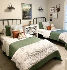 two twin beds in a bedroom with green and white bedding, one has a teddy bear on it