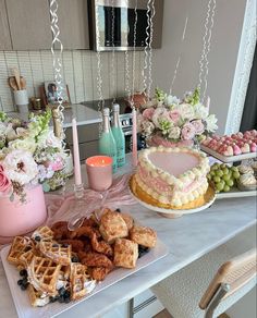 a table topped with cakes and waffles covered in frosting next to flowers