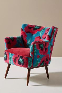 an upholstered chair with red and blue flowers on it