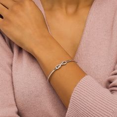 This cute diamond infinity bangle adds a touch of sparkle to any attire. Crafted in sterling silver, this look showcases a diamond-lined infinity loop layered with a smaller polished infinity symbol. Radiant with 1/5 ct. t.w. of diamonds and a brilliant buffed luster, this hinged bracelet measures 7.0 inches in circumference and secures with a tongue and groove clasp. Sterling Silver Stackable Infinity Jewelry, Fine Jewelry Infinity Necklace For Mother's Day, Silver Infinity Stackable Jewelry, Elegant Infinity Stackable Jewelry, Silver Stackable Infinity Jewelry, Sterling Silver Infinity Bracelet For Anniversary, Sterling Silver Infinity Bracelets For Anniversary, Adjustable Infinity Fine Jewelry, Fine Jewelry Infinity Stackable Pieces