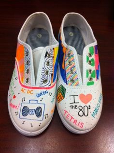 a pair of white shoes with colorful designs on the soles and one shoe has an i love 80 written on it