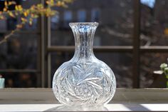 a clear glass vase sitting on top of a window sill