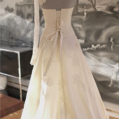 a wedding dress on display in front of a painting