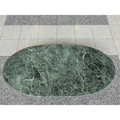 a green marble table on the ground in front of a tile floor with an oval design