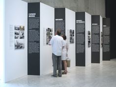 two people standing in front of some black and white pictures