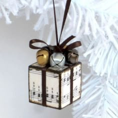 a christmas ornament hanging from a tree with musical notes and bells on it