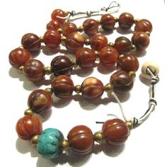 Carnelian Heirloom Dowry Beads 1 Dowry Necklace designed at Beads of Paradise with Early 20th Century Indian Carnelian melon shaped beads, Nigerian brass bicone bead spacers, an 18th century Chinese turquoise color wound glass trade bead, and a Tibetan carved Sacred Shank Turbinella Pryrum shell bead used as a clasping closure. These beautiful Carnelian gems are found in the Middle east and India, and are used as high value Dowry Currency or Bride Wealth. In traditional marriages across many cul Luxury Traditional Orange Beads, Unique Handmade Carnelian Beads, Unique Carnelian Necklaces With Large Beads, Carnelian Necklaces With Large Beads, Artisan Necklaces With Large Beads For Healing, Artisan Carnelian Beaded Necklaces, Vintage Agate Large Beads Gems And Cabochons, Artisan Hand-strung Round Beaded Necklaces, Handmade Vintage Beaded Necklaces For Meditation