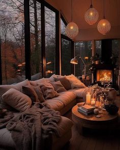 a living room filled with lots of furniture next to a window covered in lights and blankets