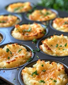 a muffin tin filled with baked potatoes topped with parmesan cheese and herbs