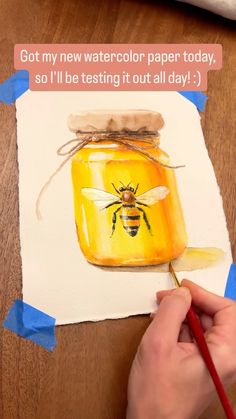 someone is painting a honey jar with watercolor paper on it and the words got my new watercolor paper today, so i'll'd be testing it out all day