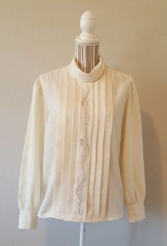 "Size 10 large blouse. Laying the garment flat bust measures 42\" waist measures 40\". For a better visual, the mannequin's measurements are bust 34\" waist 25 ½\"." Victorian Long Sleeve Tops For Fall, Vintage Tops For Fall Weddings, Fall Vintage Tops For Wedding, Vintage Fall Wedding Tops, Fall Wedding Vintage Tops, Vintage White Blouse For Spring, Cream Tops For Fall Wedding, Cream Tops For Wedding In Fall, Vintage Fashion Ruffled Blouse