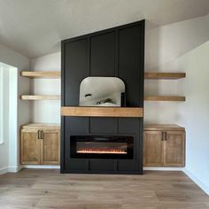 an empty room with a fireplace in the center and shelves on both sides, including cabinets