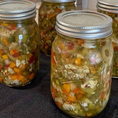 several jars filled with different types of vegetables