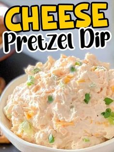 a white bowl filled with chicken salad next to pretzel dip and crackers