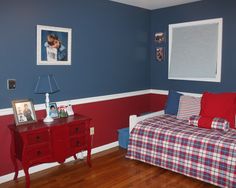 a bedroom with blue walls and red furniture in the corner is decorated with plaid bedspread