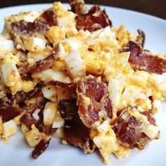 a white plate topped with bacon and eggs