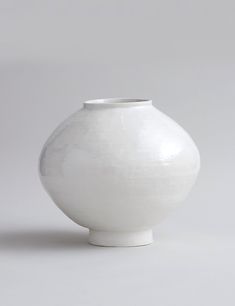 a white vase sitting on top of a table