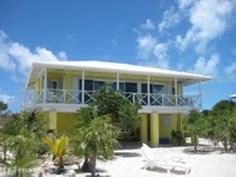 a yellow and white house on the beach