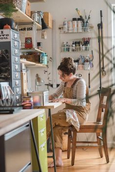 a woman sitting at a table working on something