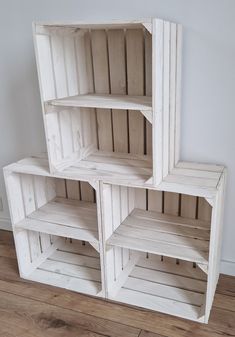 three white wooden shelves stacked on top of each other in a room with hard wood flooring