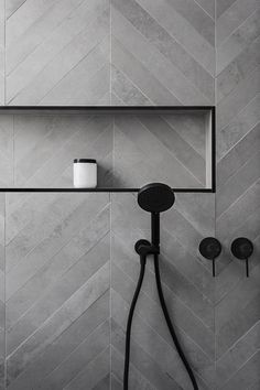 a shower head and hand held shower faucet in a bathroom with grey tile