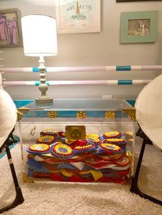 a glass table topped with lots of different colored items on top of a white rug