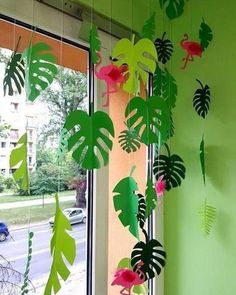 some green and pink paper leaves hanging from a window