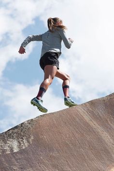 a person jumping in the air on top of a skateboard at a skate park