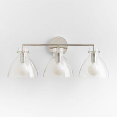 three light bathroom fixture with clear glass shades on the bottom and chrome metal arm, against a white background