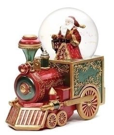 a snow globe sitting on top of a toy train with santa claus in the background