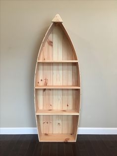 a wooden boat shaped shelf with shelves on the side