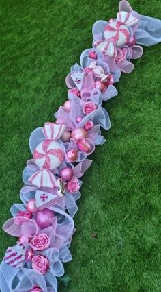 pink and white decorations on grass in the shape of a long ribbon with roses, candy bars and umbrellas