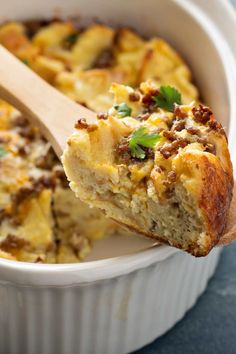 a casserole in a white dish with a wooden spoon sticking out of it