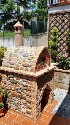 an outdoor brick oven with potted plants