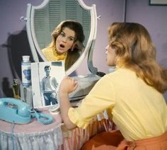 a woman is looking at herself in the mirror