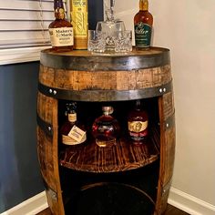 an old wooden barrel with liquor bottles on top