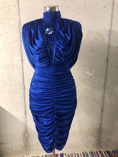 This fabulous dress features a stretchy cobalt blue fabric, a draped open back, and lace beaded neckline. The dress has a run in the back near the center waist and is mostly hidden by the back drape (pictured).   Flat measurements: Bust= 16 - 25 inches Waist= 12 - 20 inches Hips= 17 - 26 inches Neck to bottom hem= 43 inches Neck= 7 inches Tag reads:      Climax for David Howard      Made in California U.S.A. Please note: These are vintage, pre-worn and/or preloved items. I do my best to list any Blue Draped Evening Dress With Ruched Bodice, Blue Ruched Draped Evening Dress, Blue Stretch Evening Dress For Gala, Stretch Ruched Evening Dress, Stretch Royal Blue Party Dress, Royal Blue Stretch Party Dress, Blue Party Dress With Ruched Sides, Royal Blue Stretch Dresses For Party, Blue Draped Evening Dress