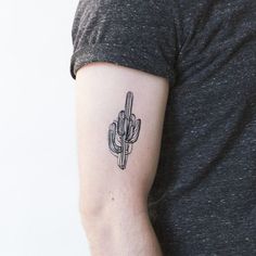 a man's arm with a small cactus tattoo on the left side of his arm