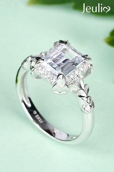 Flower Emerald Cut Sterling Silver Ring. ❤ 100% Handcrafted. This Exceptional Setting Features A Halo Of Stone Accents That Curve Gently Around The Center Gem For A Brilliant Look.  Take A Look! Elegant White Butterfly Ring For Wedding, Elegant Flower Shaped Promise Ring, Elegant Silver Butterfly Ring For Wedding, White Flower Ring With Center Stone, Elegant Silver Butterfly Wedding Ring, Flower Shaped Wedding Ring With Accent Stones, Flower Shaped Ring With Accent Stones For Anniversary, Elegant Butterfly Promise Ring With Prong Setting, White Diamond Flower Ring With Halo Setting