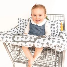 a baby sitting in a shopping cart smiling